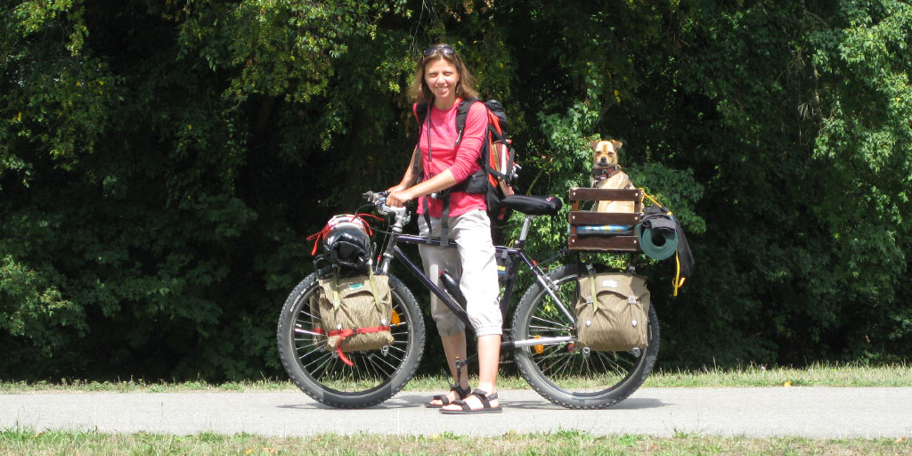 A woman and her dog on a bicycle tour across Germany.