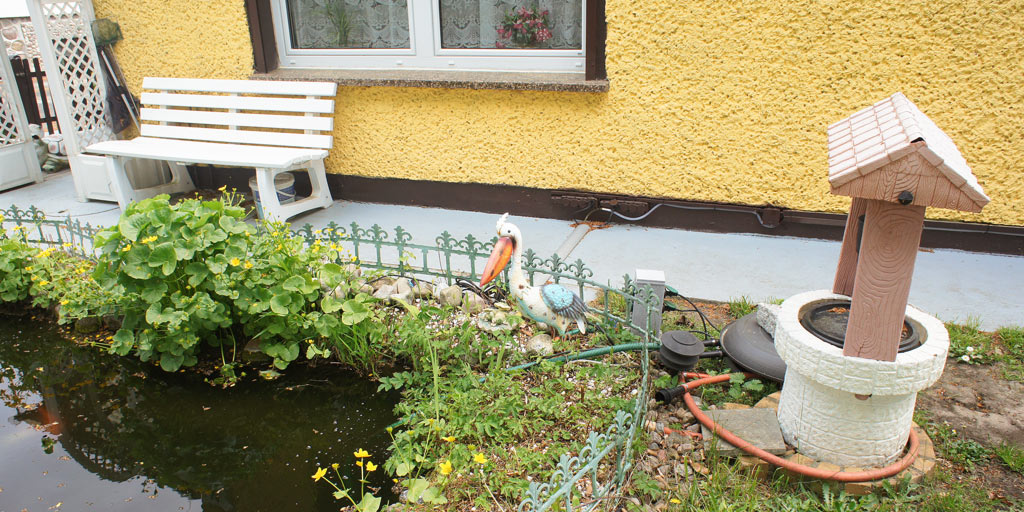 Pelican and garden decoration at a small pond.