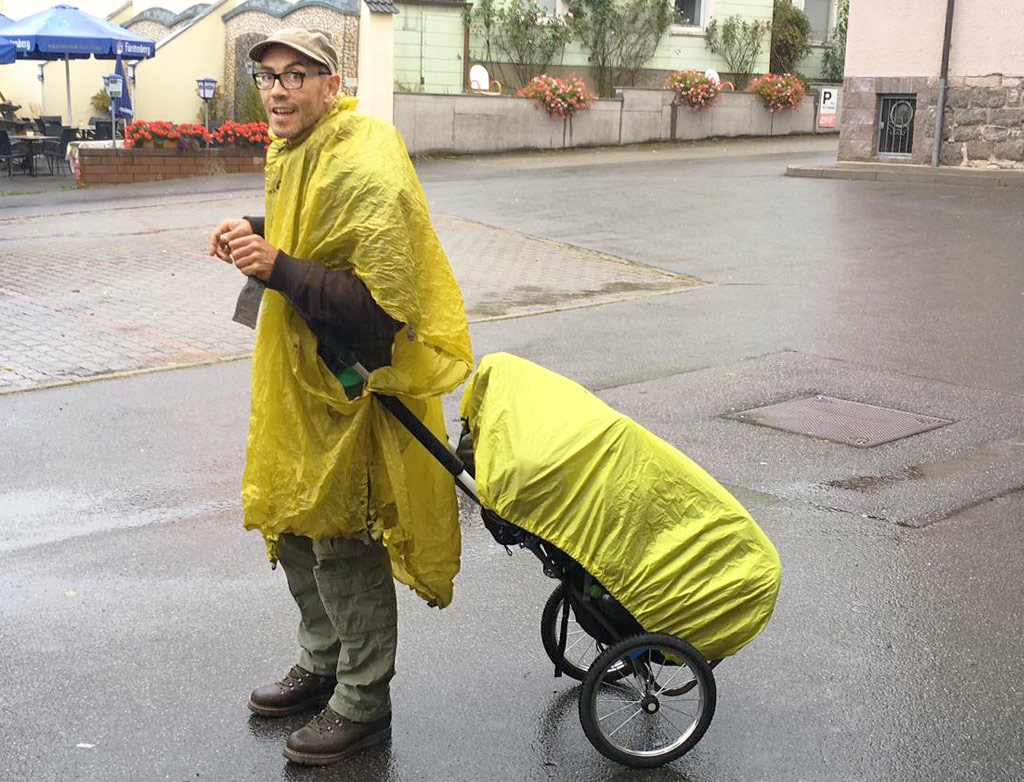 Stani hiking in bright yellow rain gear.