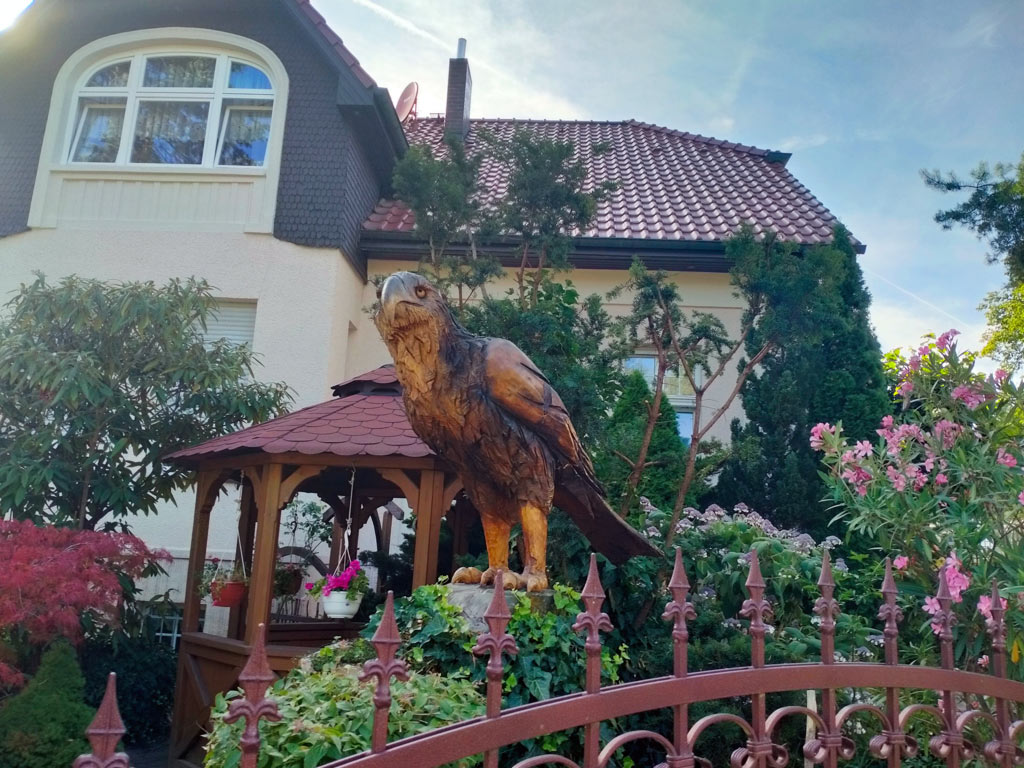 Wooden eagle and a colorful garden.