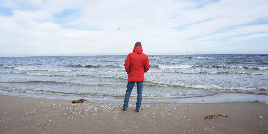 A man standing at the beach of the Baltic Sea.