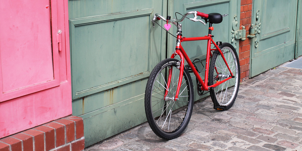 A customized red bicycle made from spare parts.